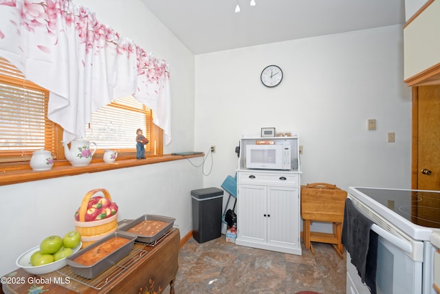 kitchen featuring white appliances and stone finish flooring