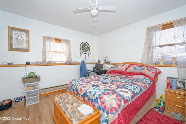 bedroom with ceiling fan, wood finished floors, and baseboard heating