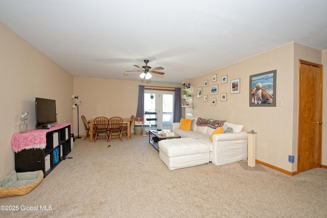 living area with baseboards, a ceiling fan, and carpet flooring