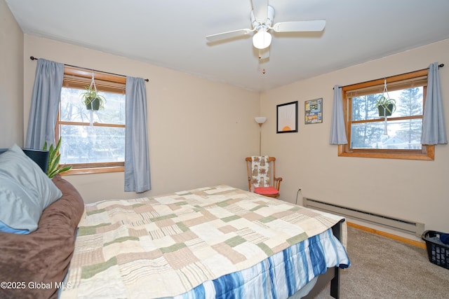carpeted bedroom with multiple windows, a baseboard heating unit, and ceiling fan