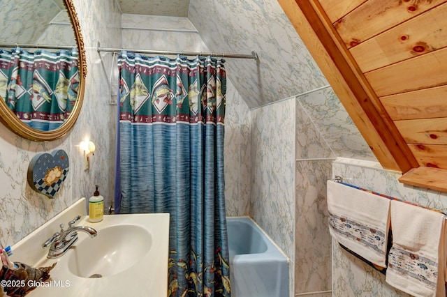 bathroom with shower / bath combination with curtain and a sink