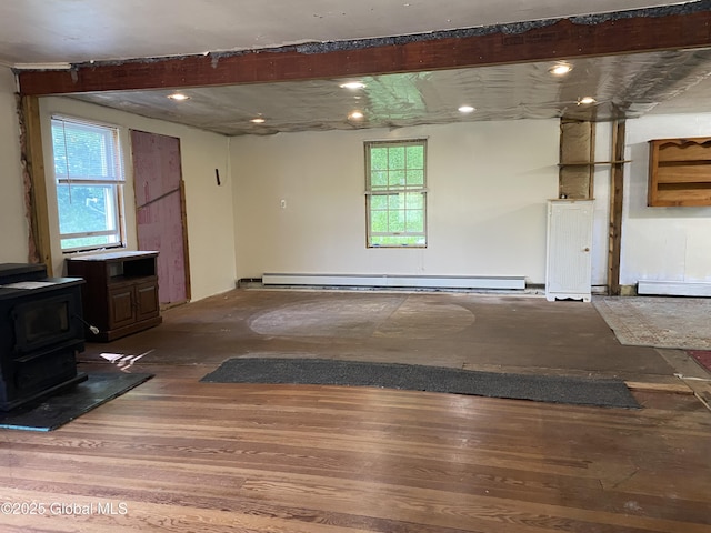 18751 State Route 22, Petersburgh, NY 12138 - unfurnished living room featuring a wood stove, wood finished floors, and a baseboard radiator