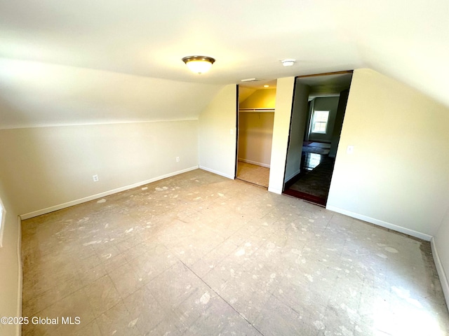 bonus room with baseboards and lofted ceiling