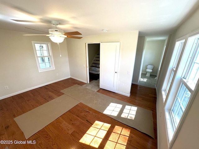 unfurnished bedroom with wood finished floors, baseboards, and ceiling fan