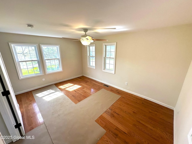 unfurnished room with baseboards, a ceiling fan, and wood finished floors