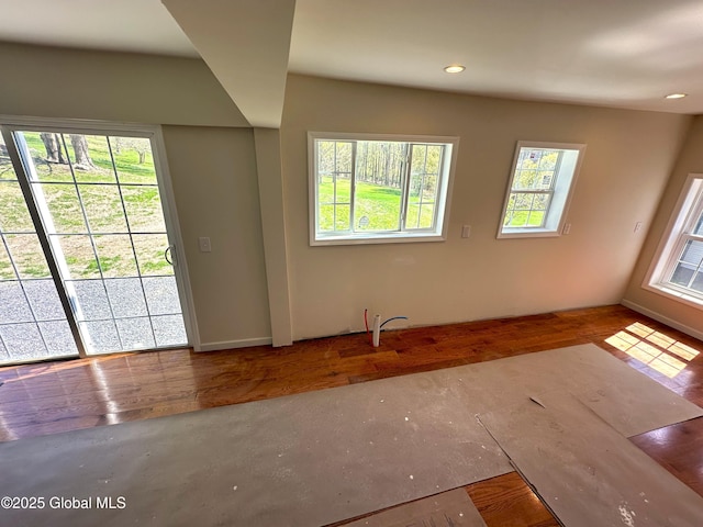 unfurnished living room with baseboards, recessed lighting, and wood finished floors