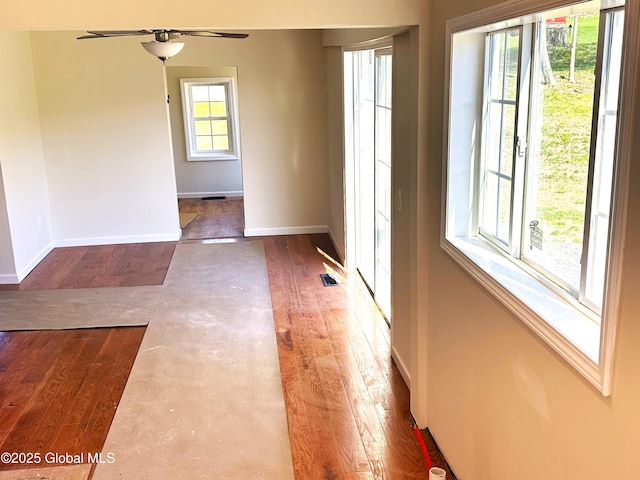 spare room featuring dark wood-type flooring, baseboards, and ceiling fan