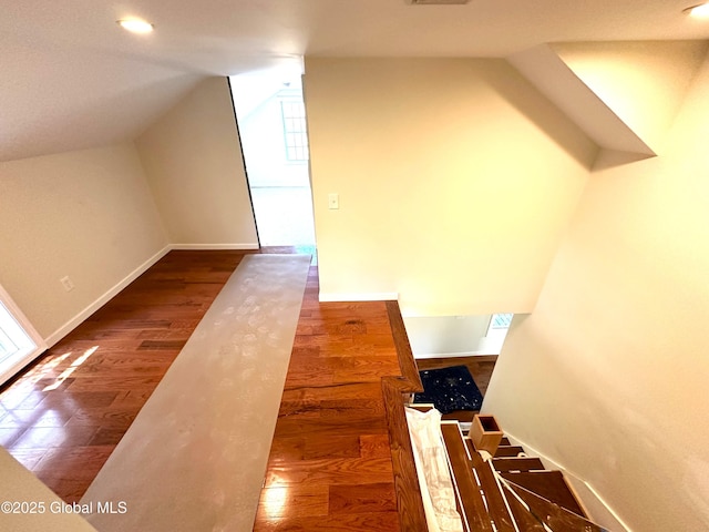 interior space featuring baseboards, wood finished floors, recessed lighting, and vaulted ceiling