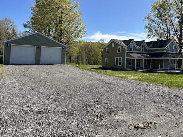 exterior space with covered porch, a detached garage, and an outdoor structure
