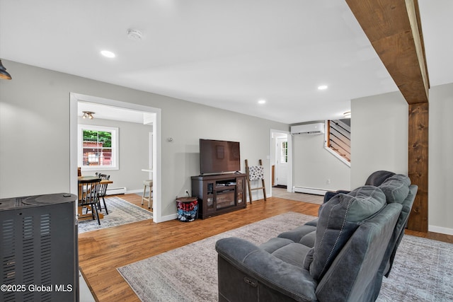 175 Library Ave, Warrensburg, NY 12885 - living area featuring a wall unit AC, wood finished floors, recessed lighting, stairs, and a baseboard radiator
