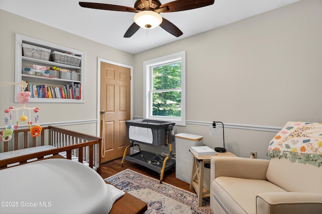 175 Library Ave, Warrensburg, NY 12885 - bedroom featuring wood finished floors, a ceiling fan, and a crib