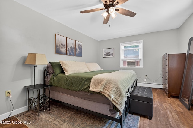 175 Library Ave, Warrensburg, NY 12885 - bedroom featuring a baseboard heating unit, wood finished floors, ceiling fan, and cooling unit