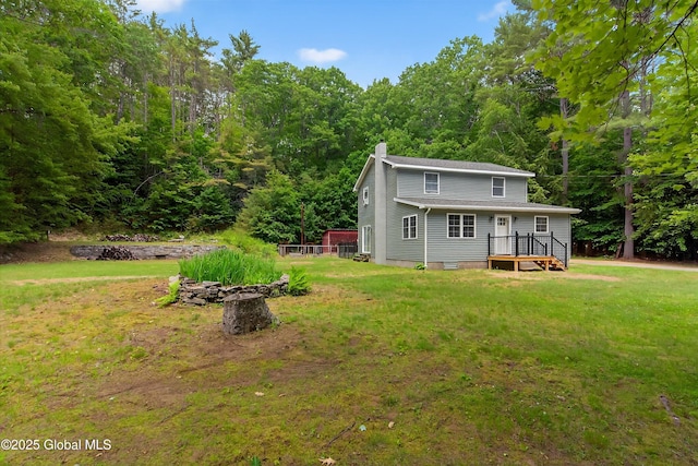 175 Library Ave, Warrensburg, NY 12885 - rear view of property featuring a chimney, a lawn, a wooden deck, and a view of trees