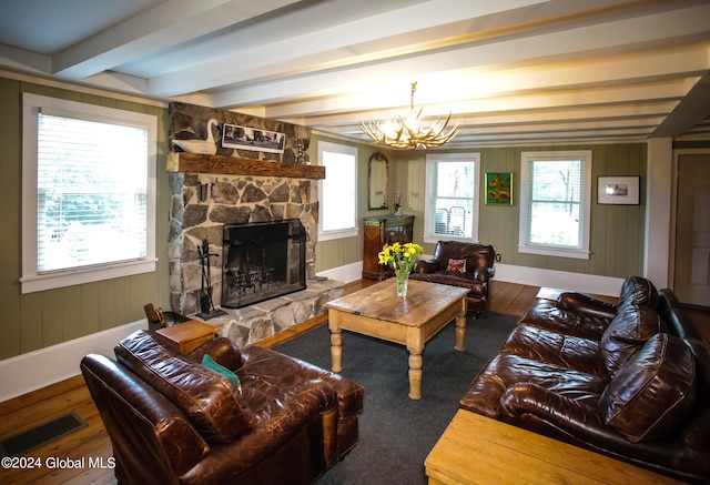 living room featuring visible vents, a fireplace, wood finished floors, beamed ceiling, and an inviting chandelier