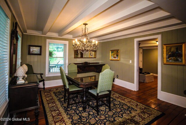 dining area with beam ceiling, baseboards, wooden walls, an inviting chandelier, and hardwood / wood-style floors