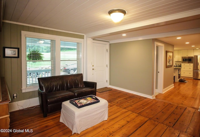 living area with wood-type flooring, ornamental molding, baseboards, and recessed lighting