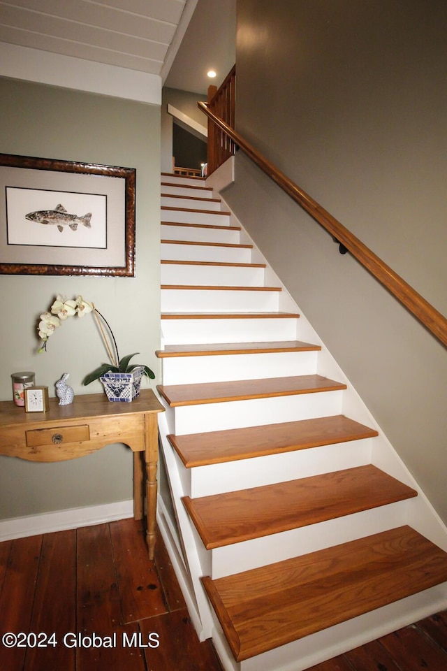 staircase with wood-type flooring and baseboards