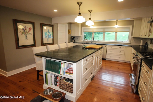 kitchen featuring a sink, appliances with stainless steel finishes, a breakfast bar area, and hardwood / wood-style floors