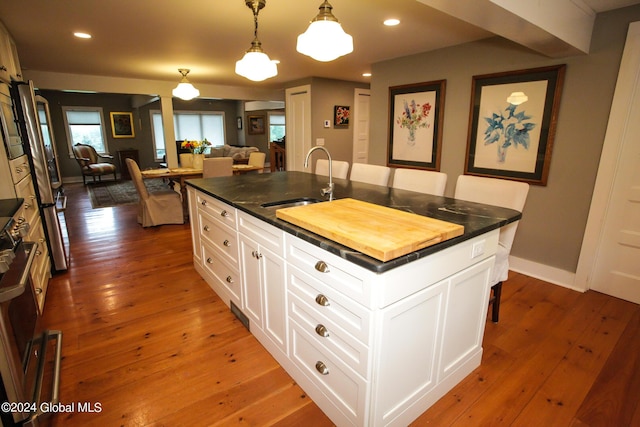 kitchen featuring a sink, an island with sink, hardwood / wood-style floors, and open floor plan