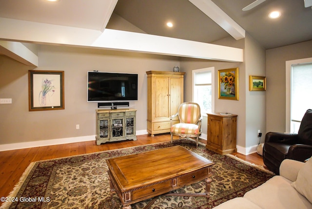 living room featuring baseboards, ceiling fan, vaulted ceiling with beams, and wood finished floors