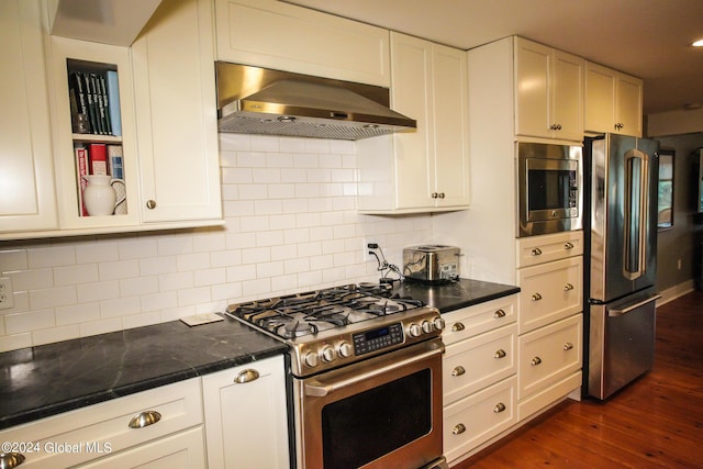 kitchen featuring dark countertops, dark wood-style flooring, appliances with stainless steel finishes, and range hood