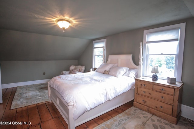 bedroom featuring wood-type flooring, baseboards, and lofted ceiling