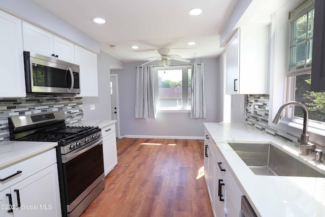 701 Engleman Ave, Glenville, NY 12302 - kitchen with stainless steel appliances, a sink, a ceiling fan, baseboards, and tasteful backsplash