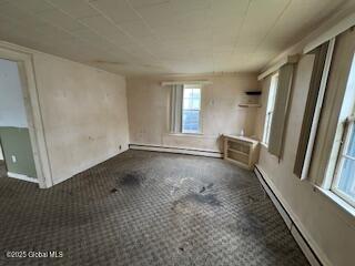 unfurnished room with baseboards, a baseboard radiator, a baseboard heating unit, and a wealth of natural light