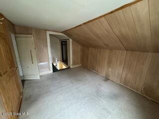additional living space with wooden walls, wood ceiling, and vaulted ceiling