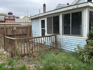 view of home's exterior featuring fence and a sunroom
