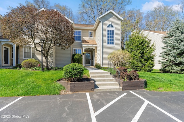 view of front facade with a front lawn and uncovered parking