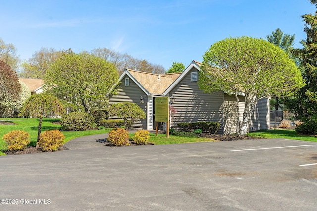 view of home's exterior with a yard and uncovered parking