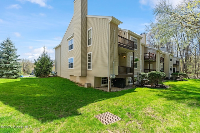 view of home's exterior with a lawn, a balcony, and a chimney