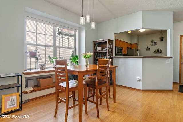 dining room featuring baseboards and light wood-type flooring