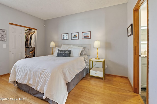 bedroom featuring baseboards, a closet, and light wood-style flooring
