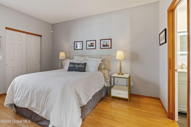 bedroom featuring baseboards, a closet, and light wood finished floors