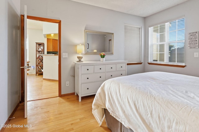 bedroom with baseboards and light wood finished floors