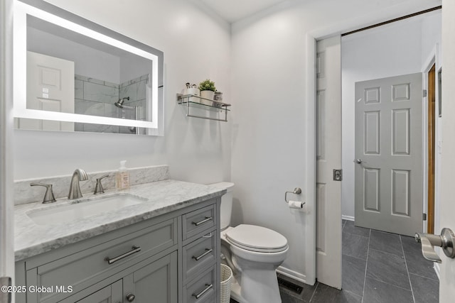 bathroom featuring toilet, a shower, and vanity
