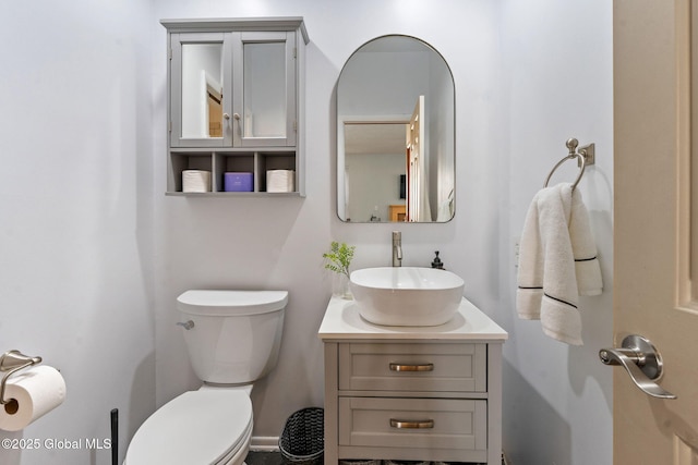 half bath featuring vanity and toilet