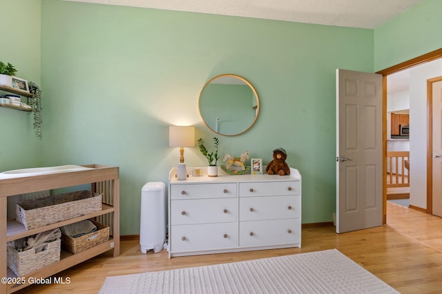 bedroom featuring baseboards and light wood finished floors