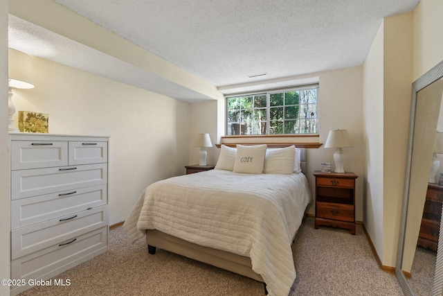 bedroom with a textured ceiling, baseboards, and light carpet
