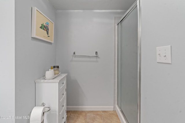 full bathroom with an enclosed shower, baseboards, and tile patterned flooring