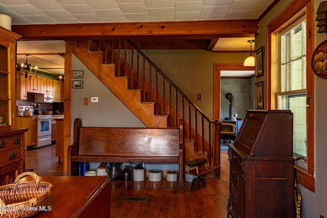 stairs featuring a wood stove and wood finished floors