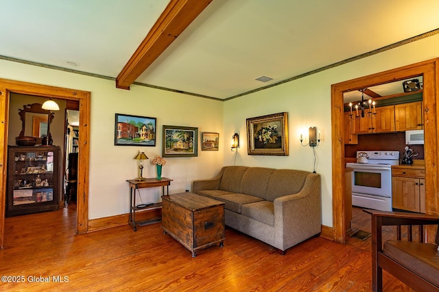 living room featuring visible vents, an inviting chandelier, wood finished floors, beamed ceiling, and baseboards