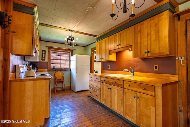 kitchen featuring a sink, a chandelier, electric stove, freestanding refrigerator, and dark wood-style floors