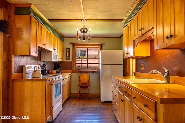 kitchen with a sink, crown molding, white appliances, and dark wood-type flooring