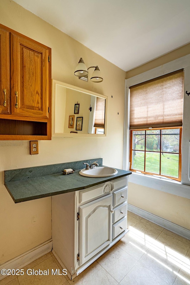 bathroom with vanity, tile patterned flooring, and baseboards