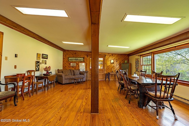 dining area with wood finished floors and wooden walls