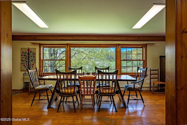 dining space with plenty of natural light and hardwood / wood-style flooring