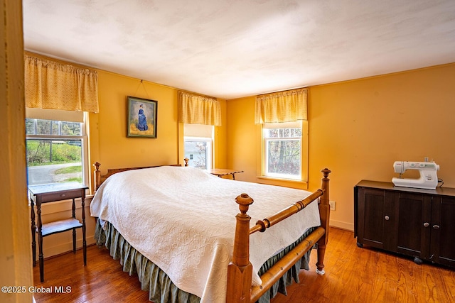 bedroom with baseboards and wood finished floors
